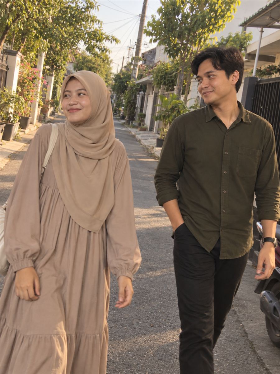 Foto kedua mempelai berjalan di jalan kampung