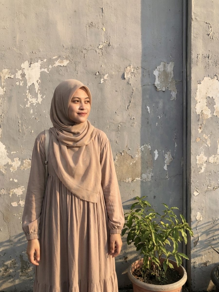 Foto mempelai wanita berdiri di depan dinding
