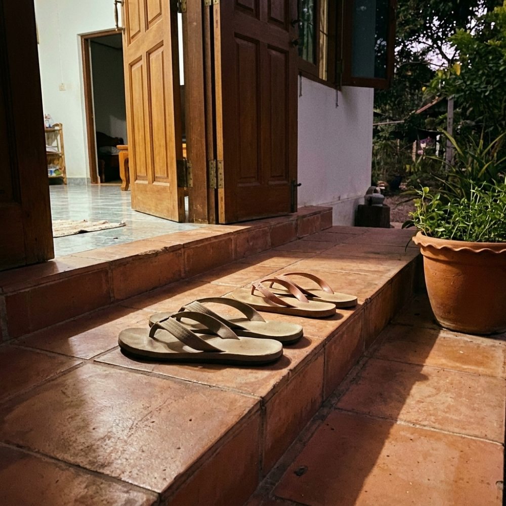 Foto dua pasang sandal di teras
